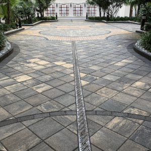 Cast iron trench drain grates with decorative Locust pattern, installed in driveway with pavers