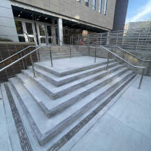 Cast aluminum decorative trench grates in Rain pattern from Iron Age Designs in college courtyard.