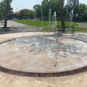 Cast iron radius trench grate in decorative Oblio pattern from Iron Age Designs. Installed in splash park.