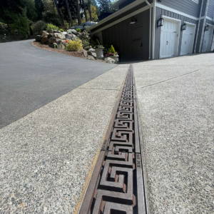 Raw cast iron trench grate in Greek Key pattern from Iron Age Designs. Installed in residential driveway.