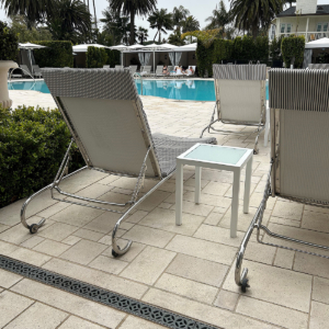 Cast bronze trench grates in decorative Interlaken pattern from Iron Age Designs. Installed on pool deck surrounded by pavers.