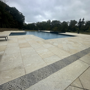 Cast aluminum trench grates in decorative Argo pattern by Iron Age Designs. Pool deck installation.