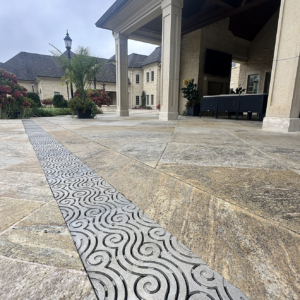 Cast aluminum trench grates in decorative Argo pattern by Iron Age Designs. Pool deck installation.