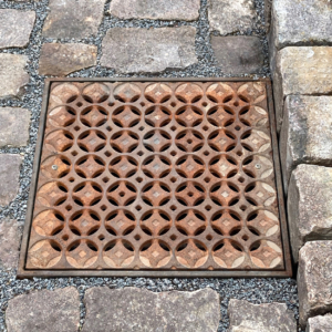 Cast iron catch basin grate in decorative Interlaken pattern by Iron Age Designs.