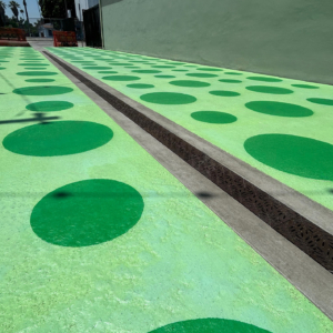 Cast iron trench grates in decorative Locust pattern by Iron Age Designs. Installed in colorful pedestrian plaza.