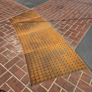 Cast iron detectable warning plates with decorative Interlaken pattern by Iron Age Designs.