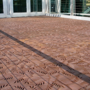 Cast iron grates in decorative Locust pattern by Iron Age Designs. Arrayed as a pedestrian bridge deck.