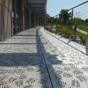 Cast aluminum grates in decorative Locust pattern by Iron Age Designs. Arrayed as a pedestrian bridge deck.