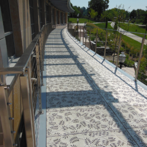 Cast aluminum grates in decorative Locust pattern by Iron Age Designs. Arrayed as a pedestrian bridge deck.