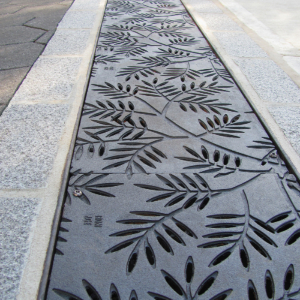 Cast iron grates in decorative Locust pattern by Iron Age Designs. Arrayed as a pedestrian bridge.