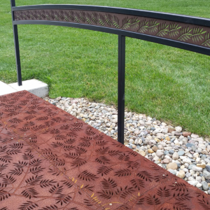 Cast iron grates in decorative Locust pattern by Iron Age Designs. Arrayed as a pedestrian bridge with matching laser cut handrail.