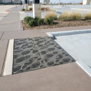 Cast iron grates in decorative Oblio pattern by Iron Age Designs. Arrayed as large stormwater inlet.